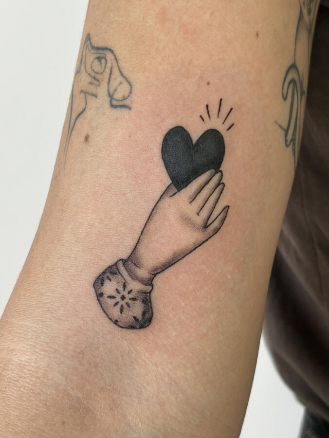 Mano tatuata con cuore e motivi decorativi - artista fineline a Roma